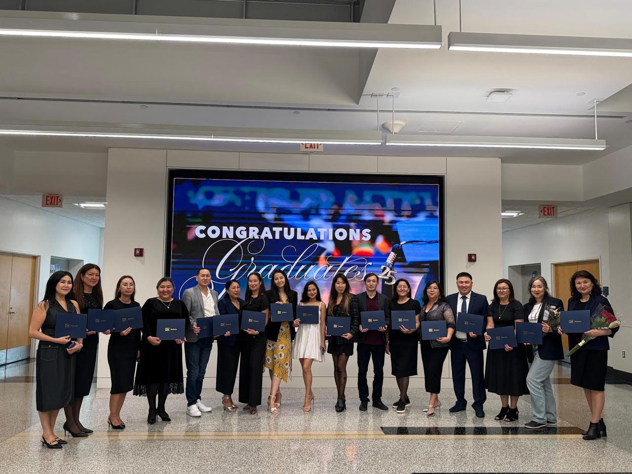 Graduates holding certificates at a George Washington University program celebration